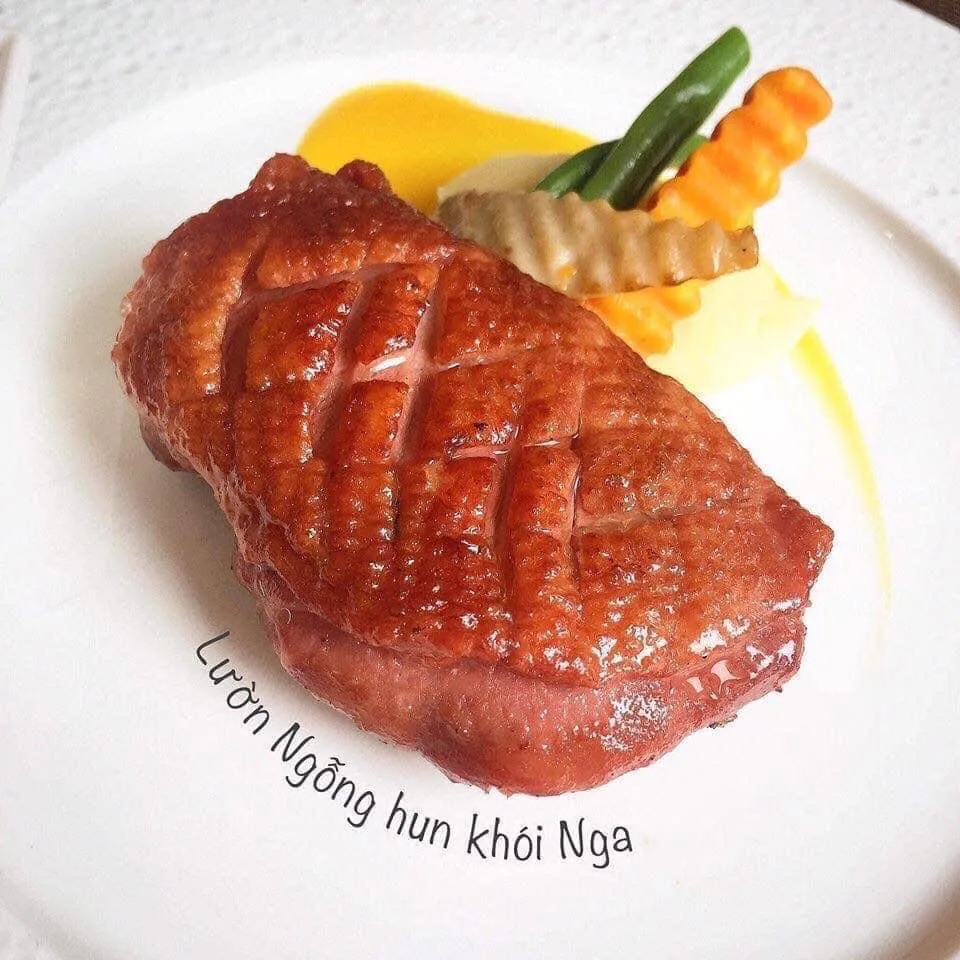 Miếng lườn ngỗng hun khói nguyên miếng, da khía ô vàng nâu, bày đĩa cùng rau củ